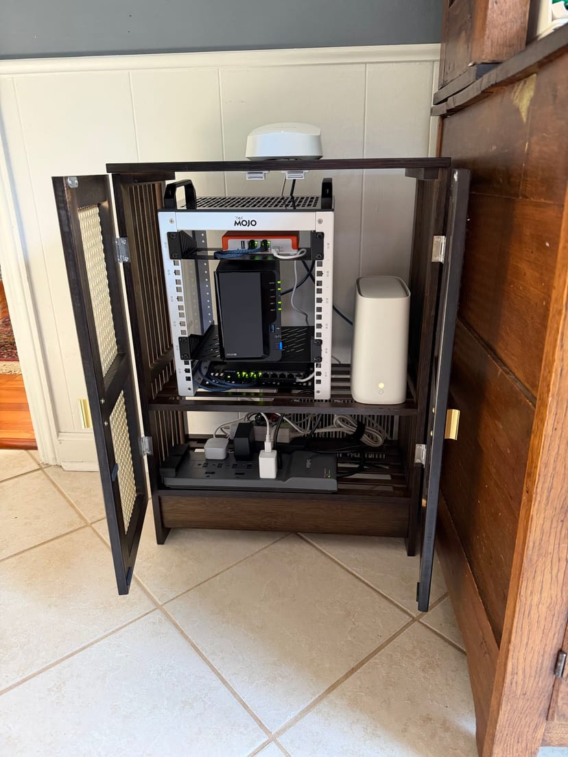 Parents rack with a white mini rack, NAS, Firewalla Orange, eero routers, and surge protector